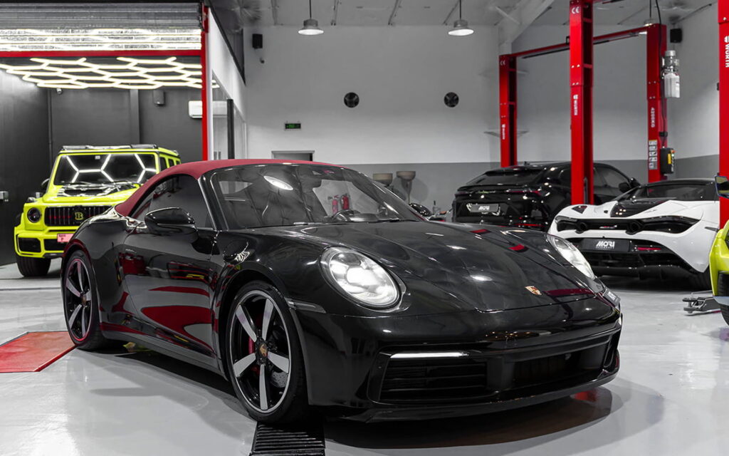 A black luxury sports car undergoing computer diagnostics for luxury cars