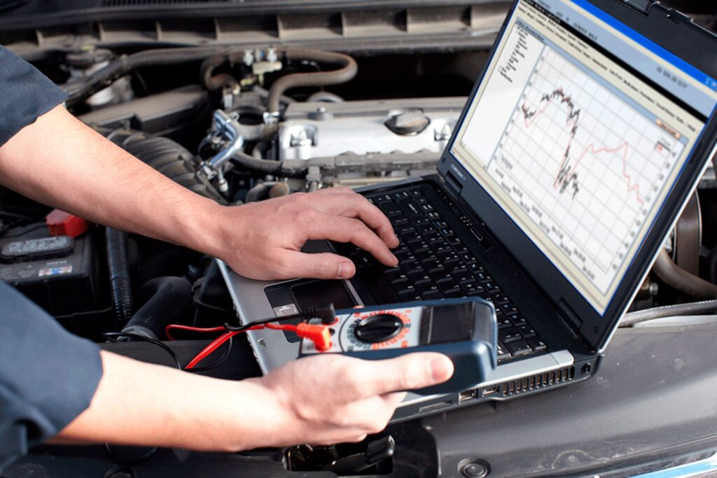 Technician diagnosing car with laptop at Mori Autoworks