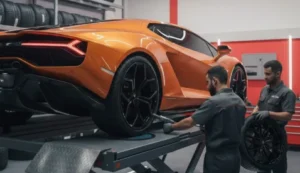 Technicians working at the rear of an orange Lamborghini on a lift at a luxury car garage in Dubai